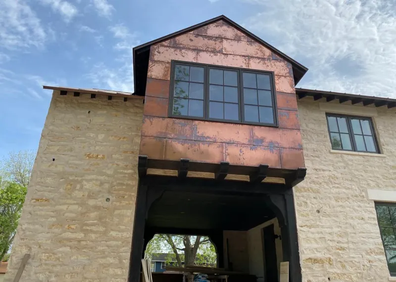 Copper metal panel facade on a stone building for Skylight Installation in Brentwood
